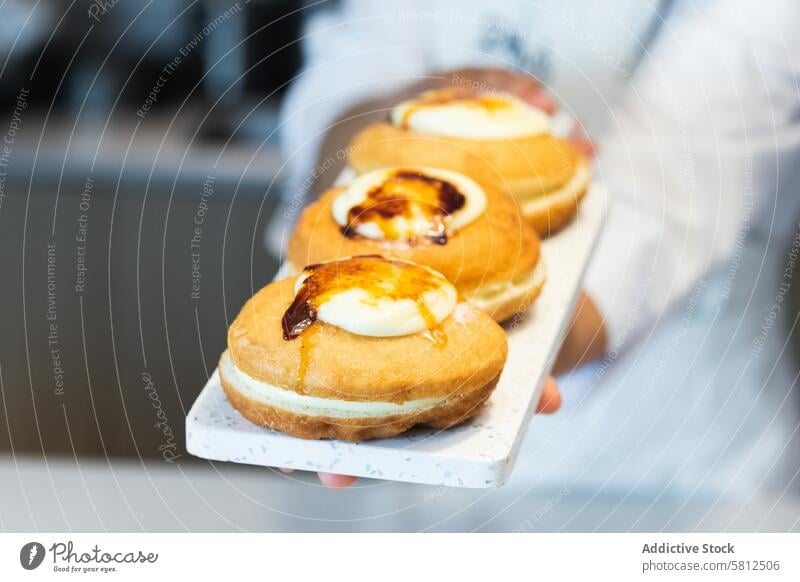 Kropfenkoch mit appetitlichen Berlinern an Bord berliner Bäcker Bäckerei Dessert Veganer süß Kruste Sahne Holzplatte Lebensmittel kulinarisch Gastronomie Küche