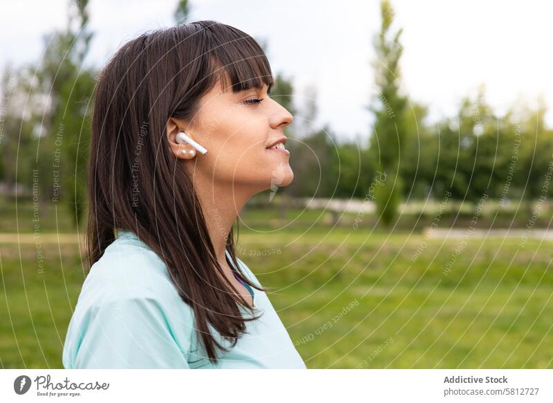 Läuferin hört entspannt Musik beim Training im Freien aktiv Sportkleidung Erwachsener Athlet sportlich Körper Pause Atmung Windstille Kaukasier Kopfhörer