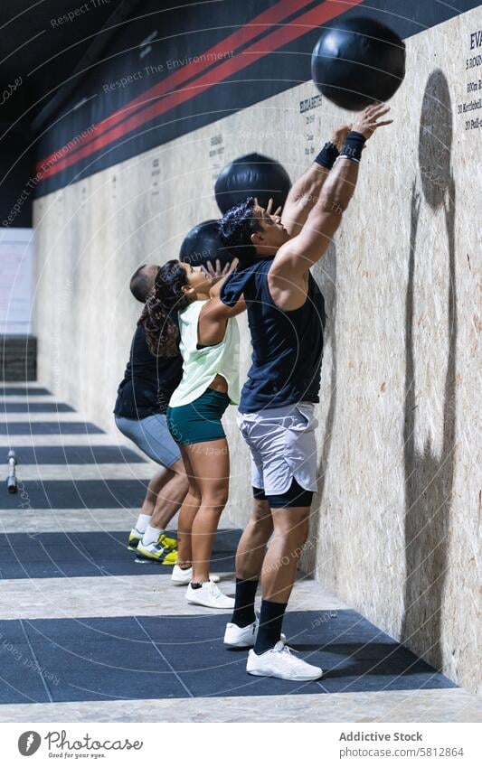 Spanische Sportler trainieren mit Medizinbällen Gewicht Medizinball Gewichtheben Kraftdreikampf Training Fitnessstudio Übung Sportlerin sportlich Frau