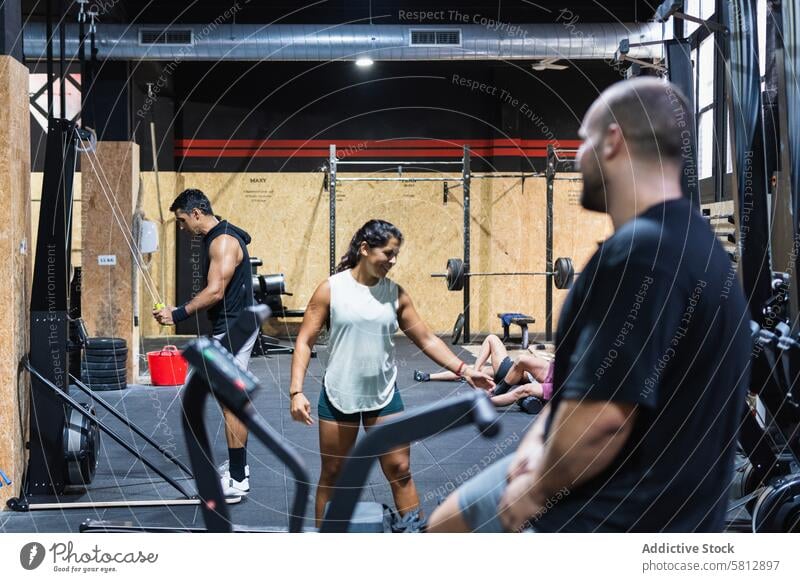 Spanische Sportler beim Training im Fitnessstudio Gesunder Lebensstil Wellness Übung Gerät Sportlerin sportlich Frau Sportkleidung Männer Sportbekleidung