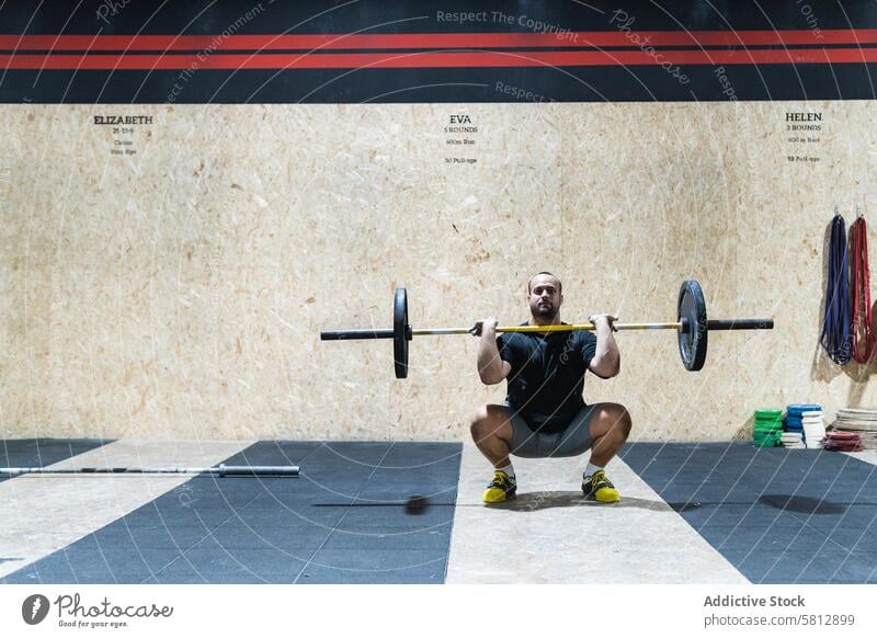 Muskulöser Sportler beim Heben einer schweren Langhantel Curl-Hantel Gewichtheben Stoßen und Stoßen Training Fitnessstudio Übung Gesunder Lebensstil Bodybuilder