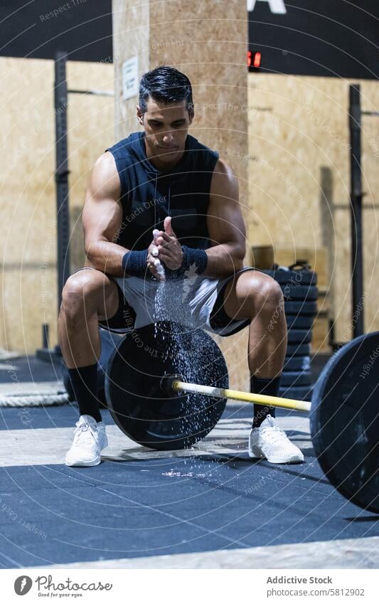 Starker hispanischer Sportler in der Nähe der Hantelstange Curl-Hantel Gewichtheber Kraftdreikampf Training Fitnessstudio Übung Talkum Gesunder Lebensstil