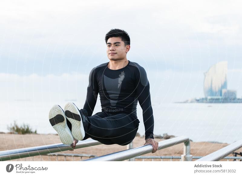 Sportler beim Training am Barren Übung parallel Athlet calisthenics gymnastisch Fitness jung Mann asiatisch ethnisch Sportpark physisch Ausdauer Lifestyle