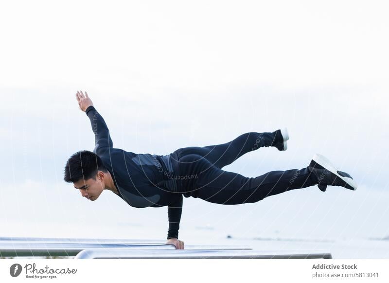 Sportlerin bei einer Übung am Barren Turner Handstand Training Athlet Gleichgewicht Fitness jung Mann asiatisch ethnisch Sportpark gymnastisch physisch Ausdauer