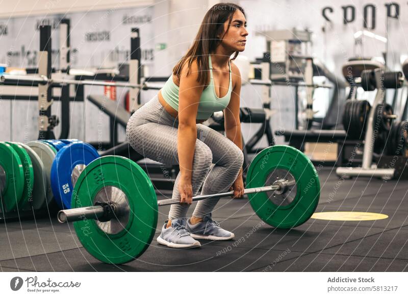 Frau Athleten tun Kreuzheben in einer Turnhalle. Seitenansicht Fitnessstudio Sport Gesundheit deadlift Stärke Training Curl-Hantel stark Menschen Gewicht