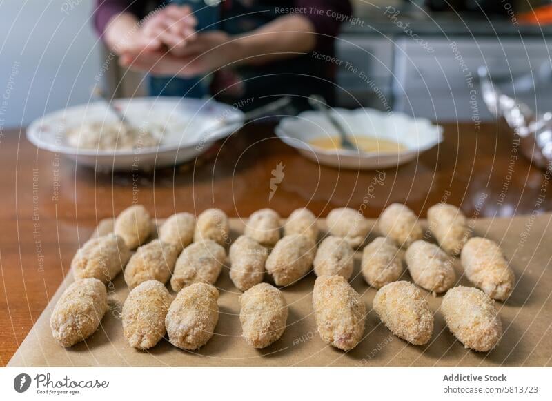 Viele Kroketten aufgereiht und bereit zum Braten Senior Frau vorbereitend viele braten Essen zubereiten Linie Anzahl & Menge kulinarisch selbstgemacht Küche