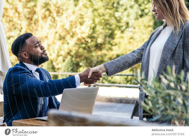 Business schwarzer Mann macht Interview mit Laptop zu einer Frau im Freien Café Afroamerikaner männlich Sitzung Team professionell Exekutive Erfolg Unternehmer