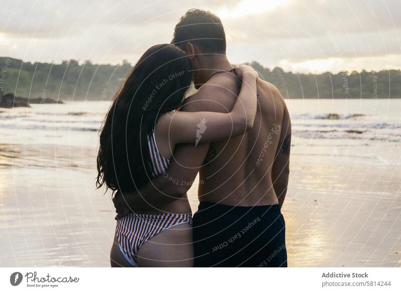 Junges Paar steht am Strand bei Sonnenuntergang Liebe Zusammensein Mann Romantik Glück Menschen jung zwei Meer romantisch Frau Urlaub Liebespaar Partnerschaft