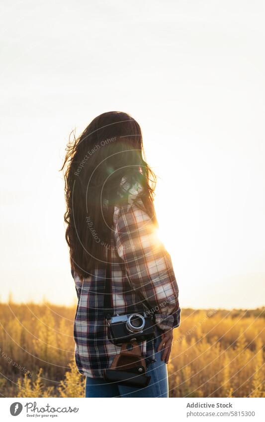 Junge Frau in Vintage-Kleidung beobachtet den Sonnenuntergang auf dem Feld Lifestyle jung Mädchen altehrwürdig retro reisen Hipster schön Menschen Hintergrund