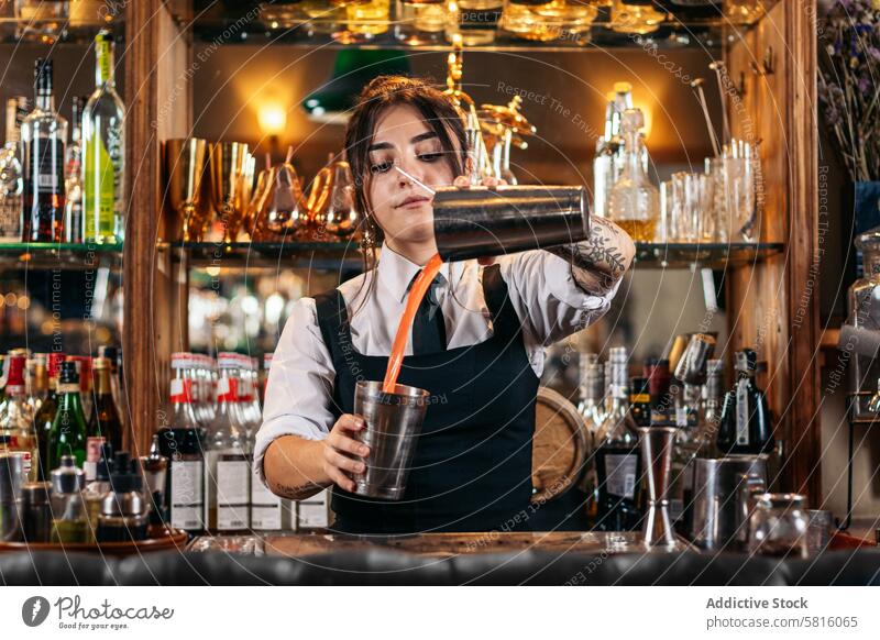 Barkeeperin bei der Zubereitung eines Cocktails in einer traditionellen Cocktailbar Barfrau Getränk Mixologe Nachtclub Alkohol Glas trinken Arbeit professionell