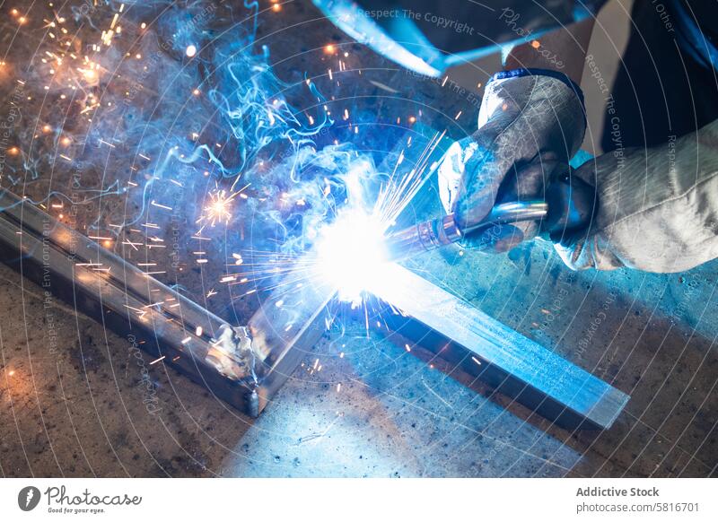 Schweißer mit Schutzhelm beim Schweißen von Metallteilen in der Werkstatt Schweißnaht Funken Mann Metallbearbeitung behüten Maschine Hobelbank männlich