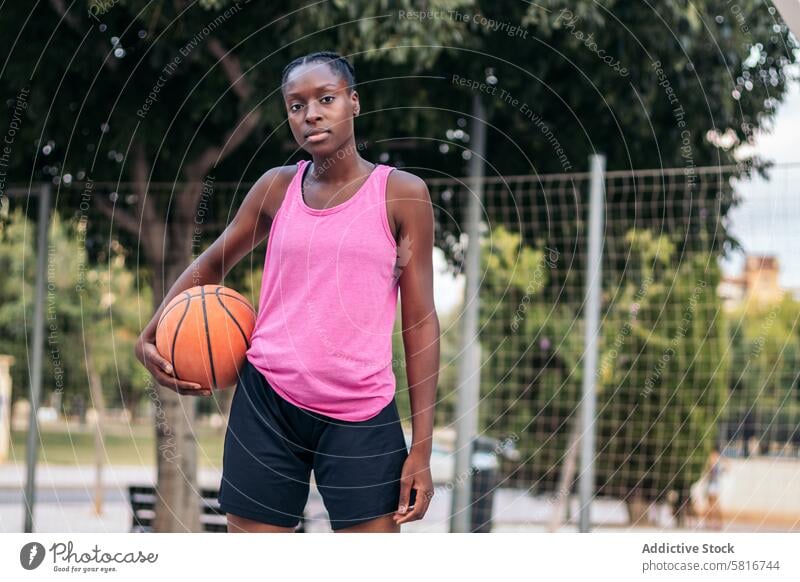 Selbstbewusster Basketballspieler, der den Ball mit Entschlossenheit hält Sport Korb jung Spiel Gericht Lifestyle Spieler urban im Freien spielen sportlich