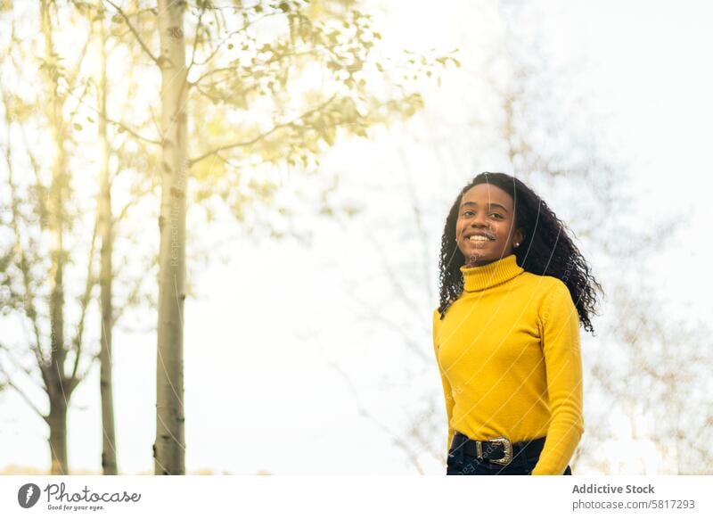 Afroamerikanisches Mädchen, das lächelnd in einem Park spazieren geht Frau Glück jung Lifestyle Afrikanisch Amerikaner Lächeln Sommer Natur Freizeit Menschen