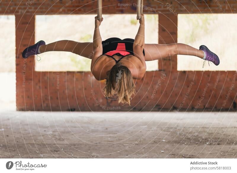 Sportlerin beim Training mit Gymnastikringen Frau Athlet Übung Gesundheit Fitnessstudio passen Körper aktiv stark sportlich Tatkraft Lifestyle jung Ringe