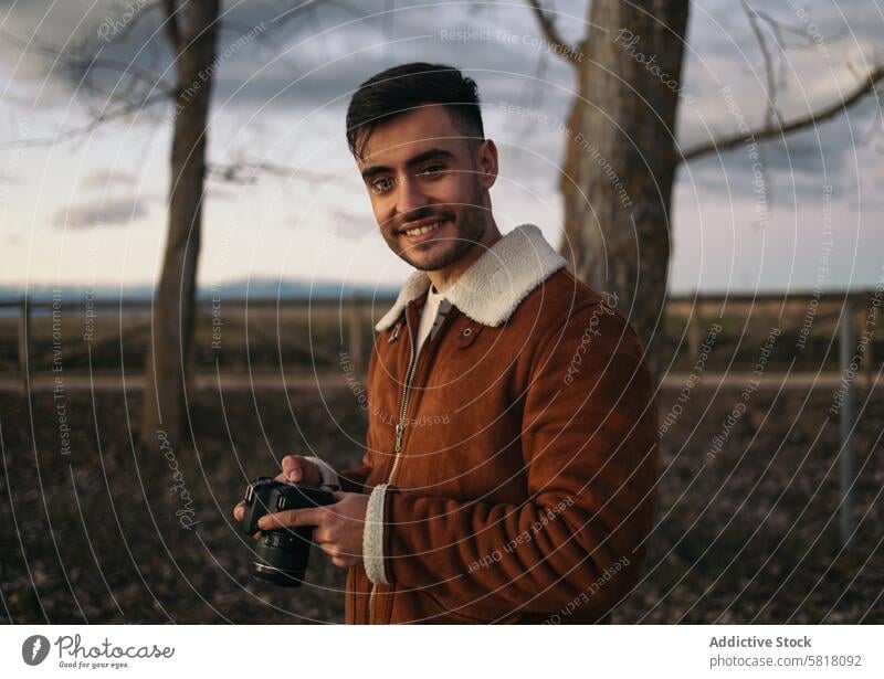 Porträt eines Fotografen, der Fotos auf dem Land macht Fotokamera Fotografie Natur natürliches Licht im Freien Lifestyle Landschaft Winter Himmel Jacke allein