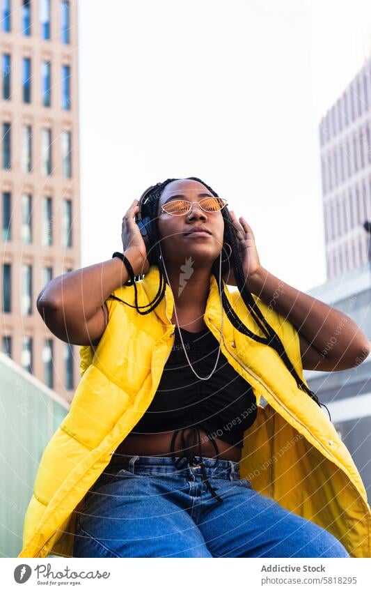 Fröhliche afroamerikanische Frau beim Musikhören in der Stadt zuhören Straße Großstadt genießen Stadtzentrum Stil Augen geschlossen trendy jung schwarz