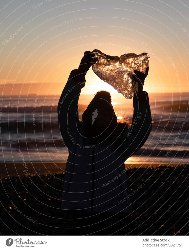 Ein Gletschereisbrocken im isländischen Sonnenuntergang Person Silhouette Island Strand Eisbrocken Sonnenaufgang im Freien Natur reisen Abenteuer Winter kalt