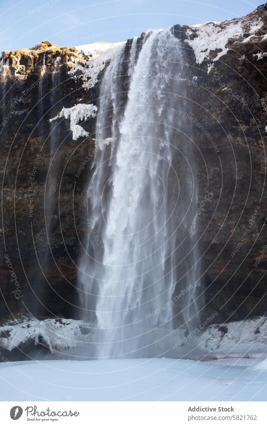 Majestätischer isländischer Wasserfall in einer Winterlandschaft Island Landschaft Natur Schönheit Schnee Klippe Kaskade fließen Natürliche Landschaft Eis kalt