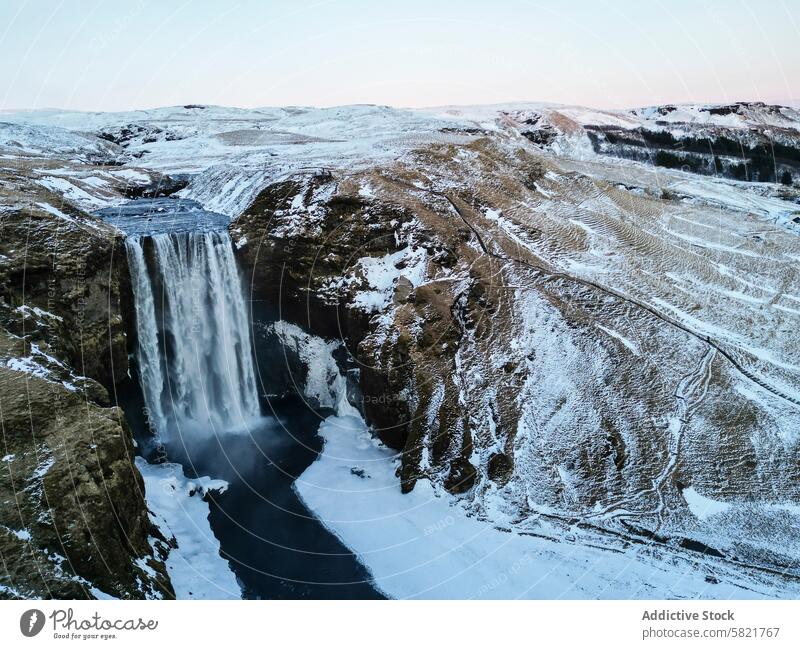 Majestätischer Blick aus der Luft auf einen verschneiten Wasserfall in Island Schnee Luftaufnahme Klippe Gelände robust Landschaft Winter Natur kalt wild