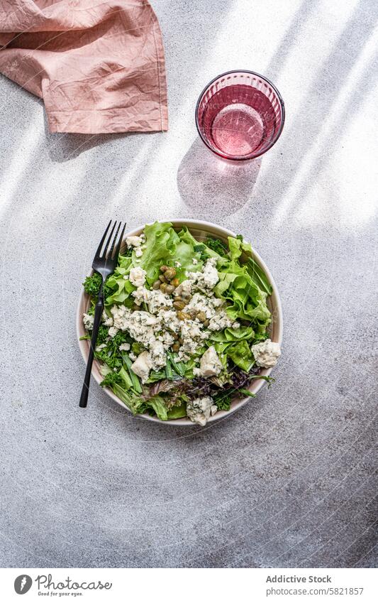 Frischer Kräutersalat mit blauem Brie und Kapern, mit Wasser Salatbeilage Kraut Frühlingszwiebel Petersilie Estragon fermentiert Kapriolen Blauschimmelkäse Käse