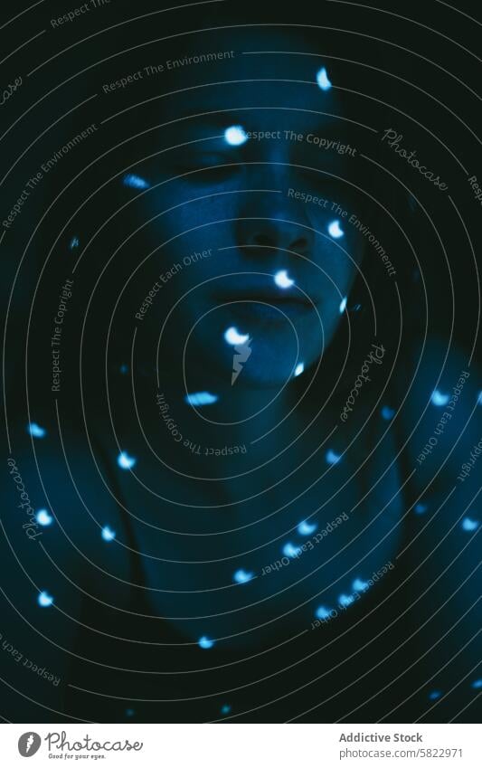 Frau in blauem Licht, die Lichtpunkte betrachtet glühen Fleck Reflexion & Spiegelung Stimmung dunkel Raum beleuchtet traumhaft Gelassenheit Gesicht Nahaufnahme