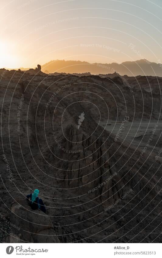 Einsames verschleiertes Mädchen in der kargen arabischen Wüste bei Sonnenuntergang Abenteuer Afrika allein in der Abenddämmerung trocken Hintergrund schön