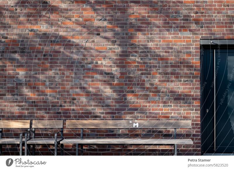 Ein Platz im Schatten Mauer Wand Bank Sitzbank Erholung Sitzgelegenheit Pause Holzbank sitzen Menschenleer Außenaufnahme ausruhen