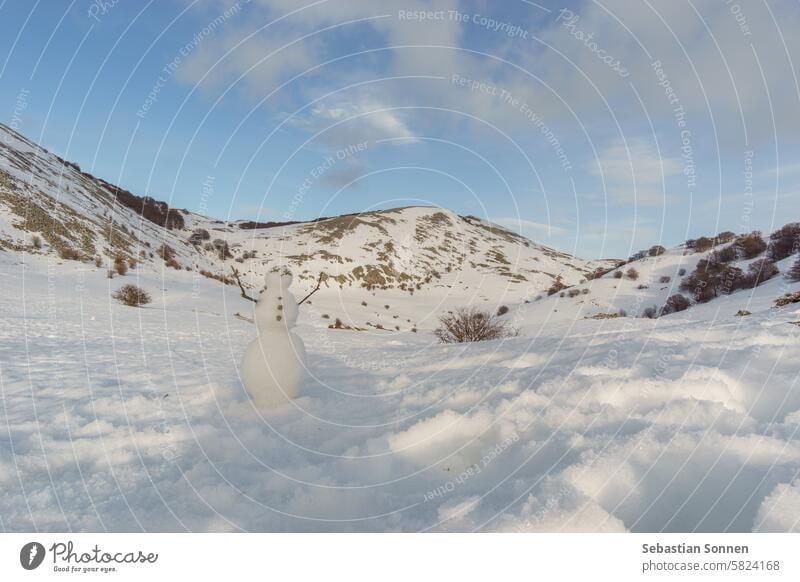 Schneemann vor der verschneiten Berglandschaft des Naturparks Madonie im Winter an einem sonnigen Tag, Sizilien, Italien Berge u. Gebirge Landschaft reisen