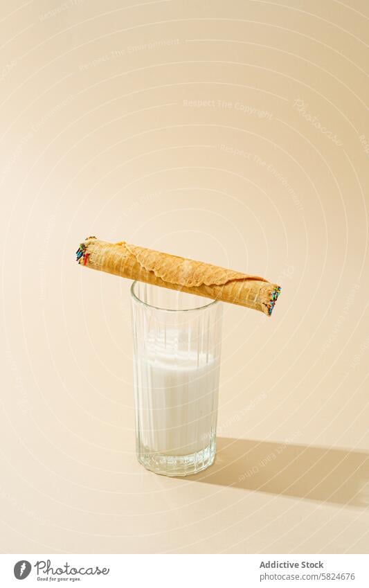 Waffelbrötchen mit Kondensmilch auf einem Glas Milch rollen melken beige Hintergrund Lebensmittel Dessert süß Knusprig gefüllt Lehnen satt Molkerei Snack cremig