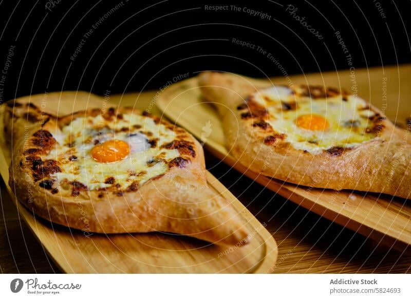 Traditionelle georgische Chatschapuri auf Holzbrettern serviert Georgien Küche khachapuri Käse Ei Brot hölzern Holzplatte rustikal traditionell Mahlzeit