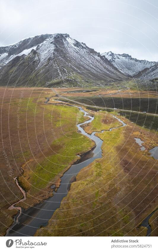 Ruhige Luftaufnahme eines mäandernden Flusses im Hochland Antenne Ansicht schlangenförmig Highlands Landschaft ruhig schneebedeckt Berge Gelassenheit riesig