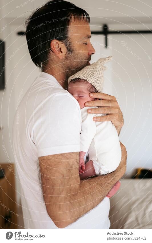 Zärtlicher Moment zwischen Vater und neugeborenem Baby Umarmen Strickmütze Angebot Liebe Elternschaft Familie Beteiligung Zuneigung Wärme heimwärts Säugling