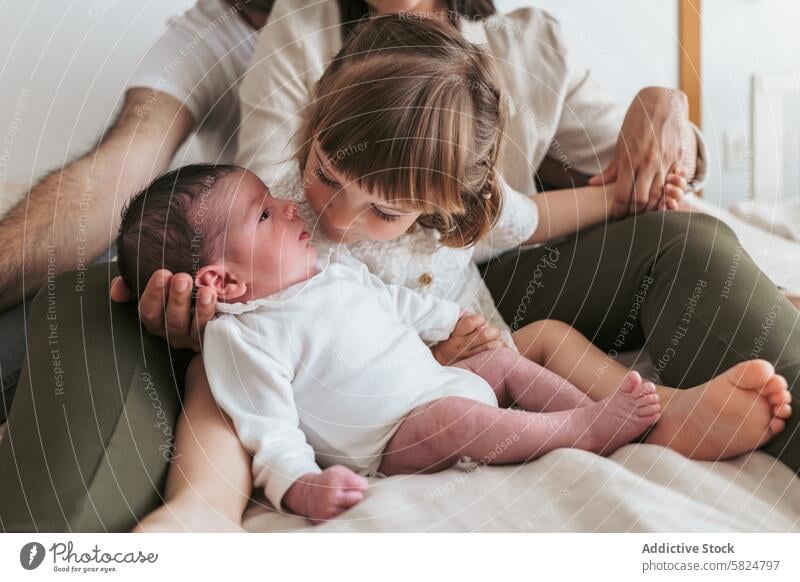 Zärtlicher Moment zwischen Geschwistern und neugeborenem Baby zu Hause Angebot Geschwisterkind heimwärts Kind sanft Beteiligung Eltern abstützen Familie Liebe