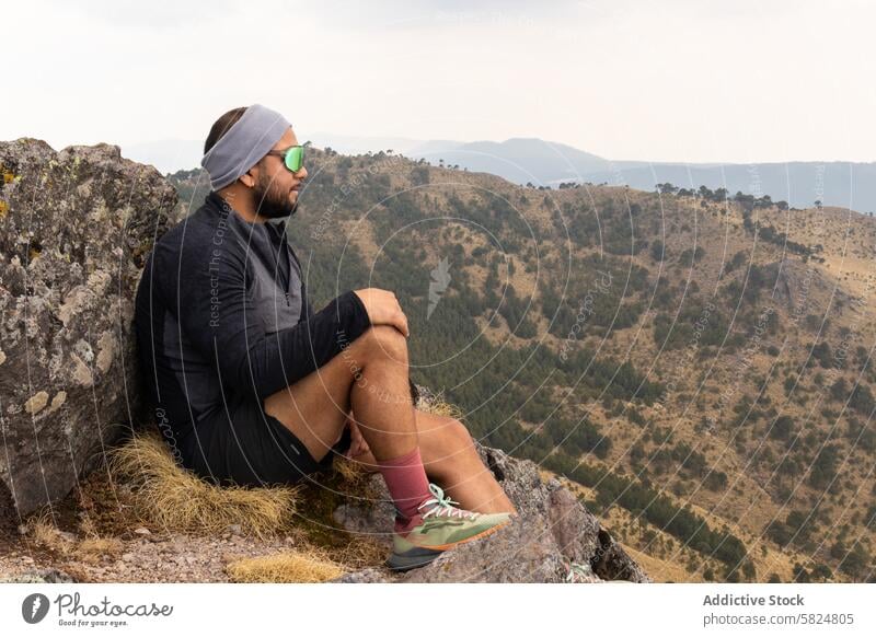 Nachdenklicher Wanderer auf dem Berggipfel während einer Trainingseinheit Berge u. Gebirge Nachlauf aussruhen Kontemplation malerisch Wanderung Sitzung Mann