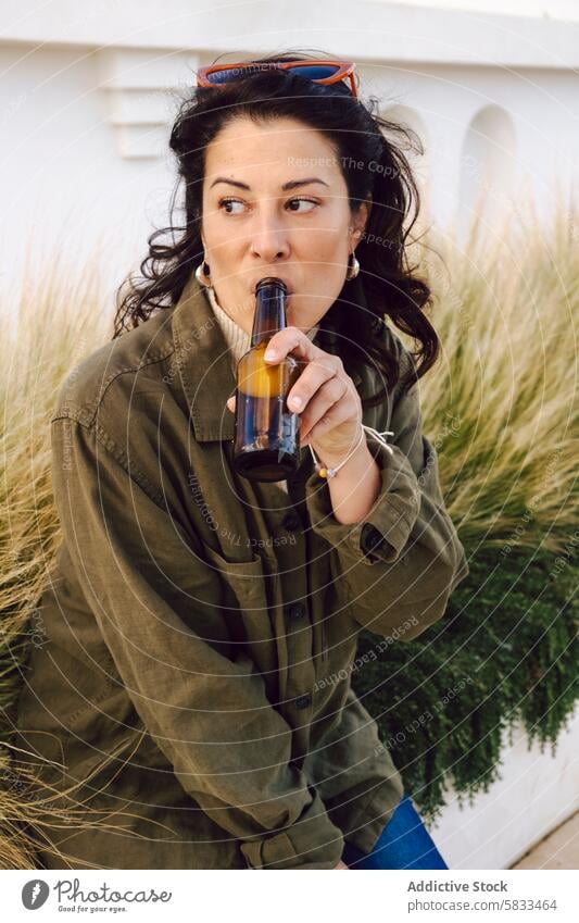 Frau genießt ein Bier am Hafen trinken Portwein lässig entspannt Ausdruck Flasche schlürfend hafen Freizeit Erwachsener im Freien tagsüber Erholung Genuss