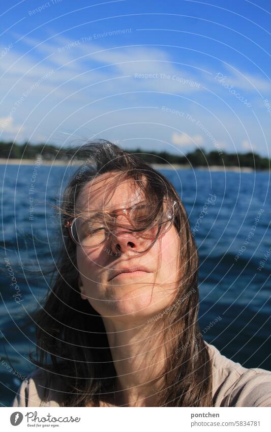 eine frau im boot mit geschlossenen augen vor meer. entspannung, erholung, genuss überleben kopf Mensch wasser brille brise urlaub augen geschlossen