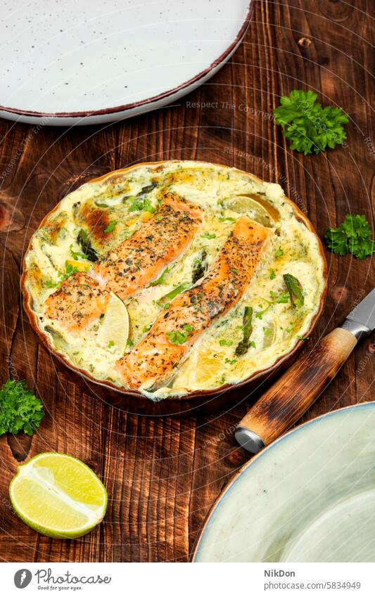 Lachsauflauf oder Gratin auf Holzuntergrund. Fisch Gemüse Auflaufform Mittagessen Lachsgratin Fisch-Schmortopf Kraut Farbbild keine Menschen Protein