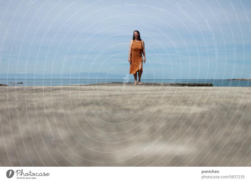 frau auf einem Steg aus Beton am Meer. meer urlaub steg ferien kleid Fröhlichkeit Kaukasier Leben bewölkt Natur Lifestyle körper Ferien & Urlaub & Reisen