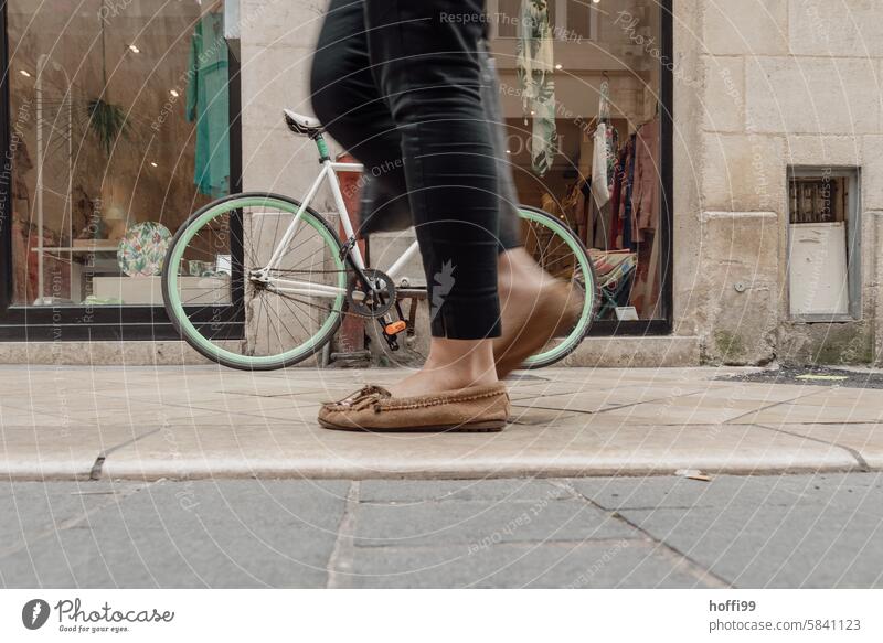 ein  retro vintage Rennrad an der Mauer wird von vorbeigehenden  Beinen verdeckt - wie schade Retro-Trash Retro-Rennrad Minmalismus streng geometrisch urban