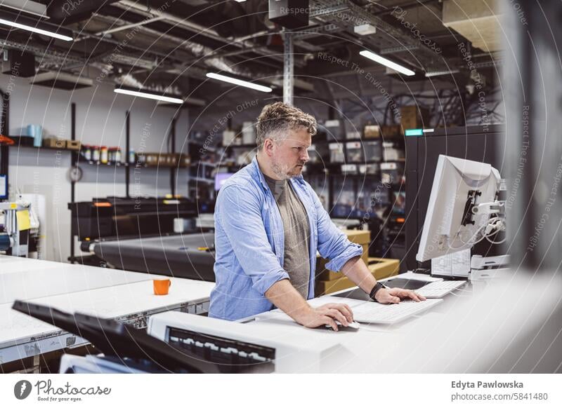 Mann bei der Arbeit in einer Druckerei Business Mitarbeiter Fabrik männlich industriell Industrie Job Güterverkehr & Logistik Herstellung Beruf Menschen