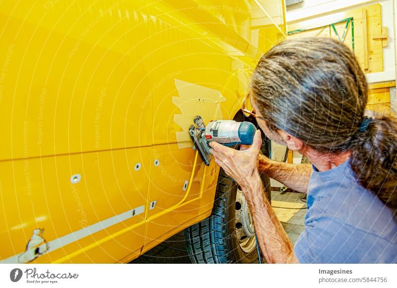 DIY Umbau eines Camper Van. Strom Steckdose für Wohnmobile außen mit einer elektrischen Stichsäge. Vorbereitung für die Installation einer externen 240-V-Steckdose für Wohnwagen