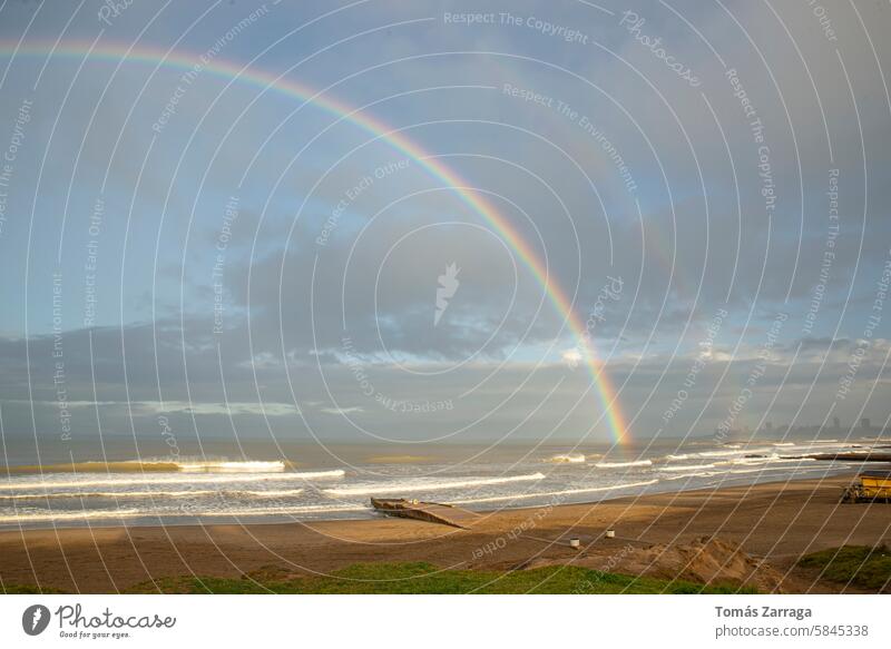 Meereslandschaft bei Sonnenuntergang Regenbogen am Strand und stürmischer Himmel Bogen MEER Meeresufer Wellen Sand Natur braun blau dunkel Horizont Wolken