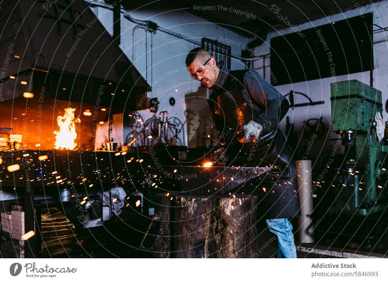 Schmied bei der Arbeit mit geschmolzenem Metall in der Schmiede Hufschmied schmieden funkt Handwerkskunst Fähigkeit erwärmen männlich heiß bügeln Feuer Amboss