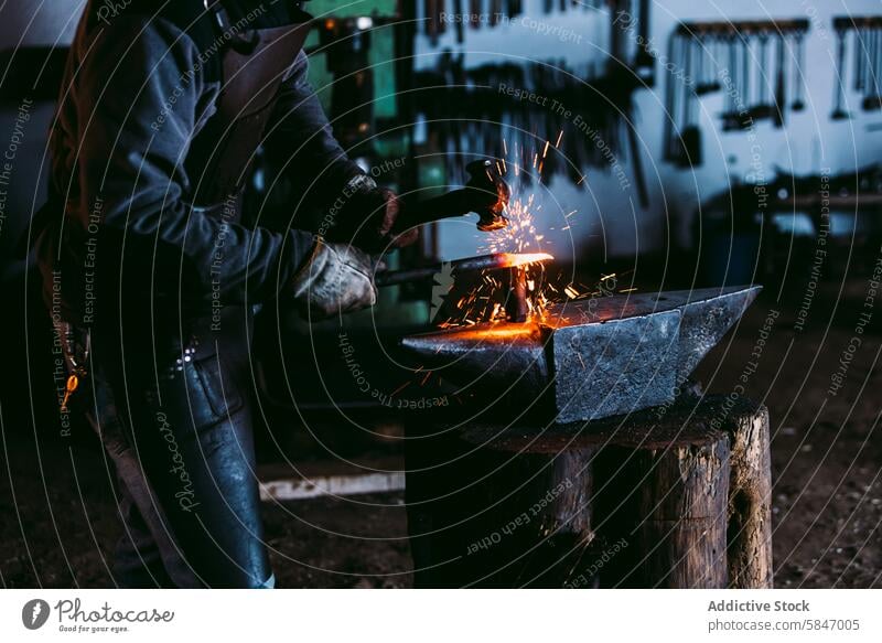 Schmied formt Metall auf einem Amboss mit Funkenflug Hufschmied funkt Schmieden bügeln Werkstatt unkenntlich Handwerk traditionell Hammer heiß Kunstgewerbler