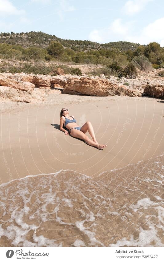 Gelassene Strandentspannung mit sonnenbadender Frau Sonnenbad Erholung ruhig sandig sanft winken Natur vereinzelt Gelassenheit im Freien Freizeit Sommer