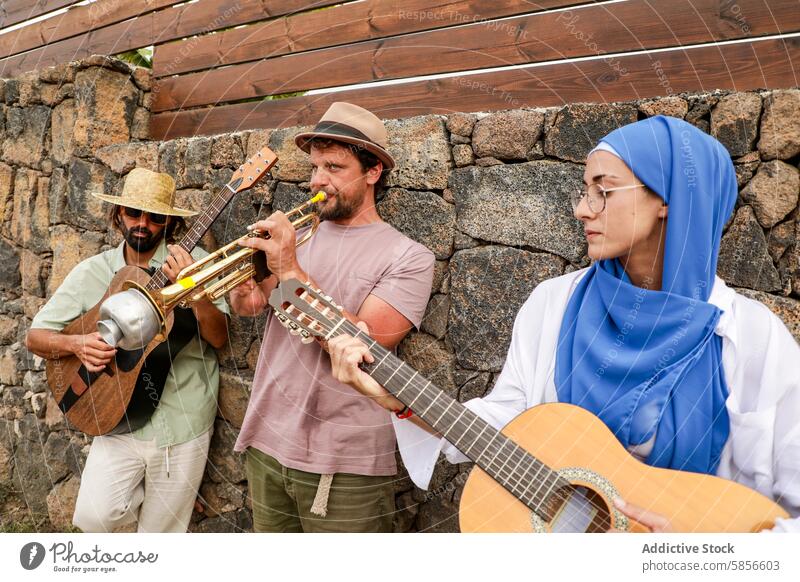 Multiethnische Freunde genießen Musik und geselliges Beisammensein im Freien Sammeln Gitarre Trompete multiethnisch vielfältig Menschengruppe Kaukasier