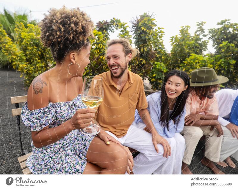 Freunde genießen Gespräche und Wein im Freien lachen Weinglas Lächeln Afroamerikaner Kaukasier asiatisch hispanisch vielfältig multiethnisch Freude