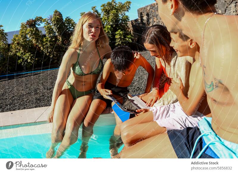 Drillinge und Geschwister teilen sich ein Tablet am Pool Tablette sonnig Tag Schwimmsport Familie Bonden Technik & Technologie Freizeit im Freien Sommer Mädchen