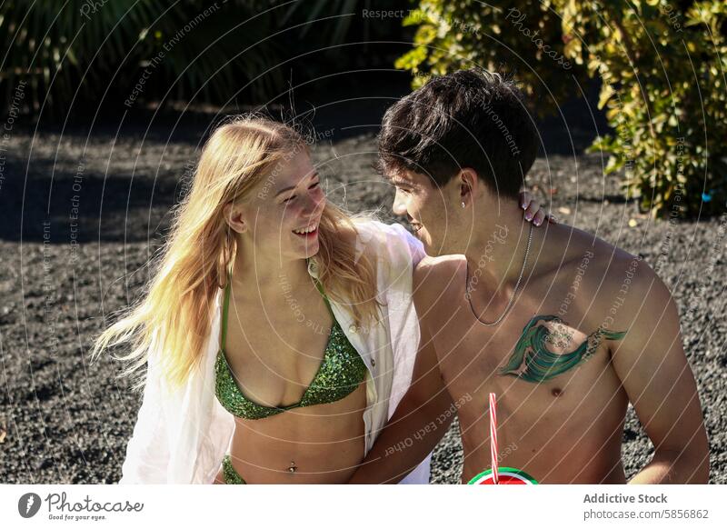 Junges Paar lächelt sich am Strand an jung Lächeln Badebekleidung Sommer Frau Mann sonnig erfrischend Schwingung männlich Glück Freude Freizeit Urlaub schwimmen