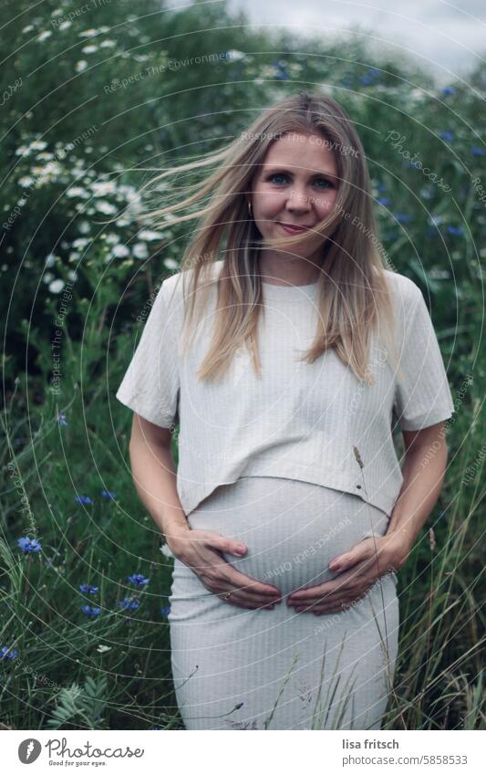 SCHWANGER - WINDIG - BLUMEN Frau schwanger Schwangerschaft jung hübsch lange Haare windig Blumen Lächeln erwartungsvoll Babybauch Bauch feminin erwarten